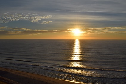 Sunrise rays of light over ocean water